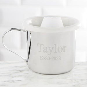 May include: A stainless steel sippy cup with a white lid and a handle. The cup is engraved with the name "Taylor" and the date "12-30-2023".