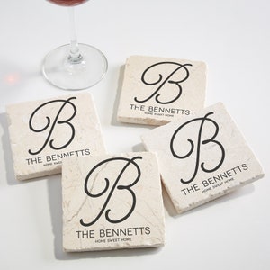 May include: Set of four beige marble coasters with a black cursive letter "B" and the text "THE BENNETTS HOME SWEET HOME" on each coaster.