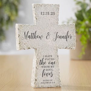 May include: A white stone cross with the text "12.31.23", "Matthew & Jennifer", "I have found the one whom my soul loves", and "Song of Solomon 3:4".