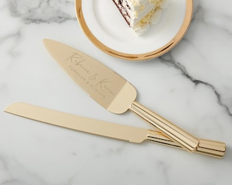 May include: A gold-colored cake server and knife set with the inscription "Rebecca & Kevin Forever & Always." The set is placed on a marble surface next to a plate with a slice of cake.