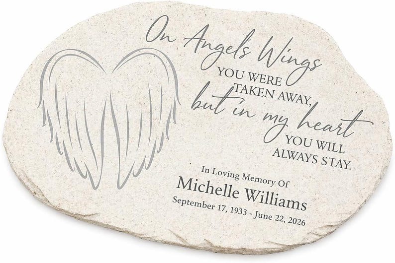 May include: A light-colored stone memorial with the text "On Angels Wings...but in my heart you will always stay." A gray wing design is on the left. The memorial is in loving memory of Michelle Williams, born September 17, 1933, and passed June 22, 2026.