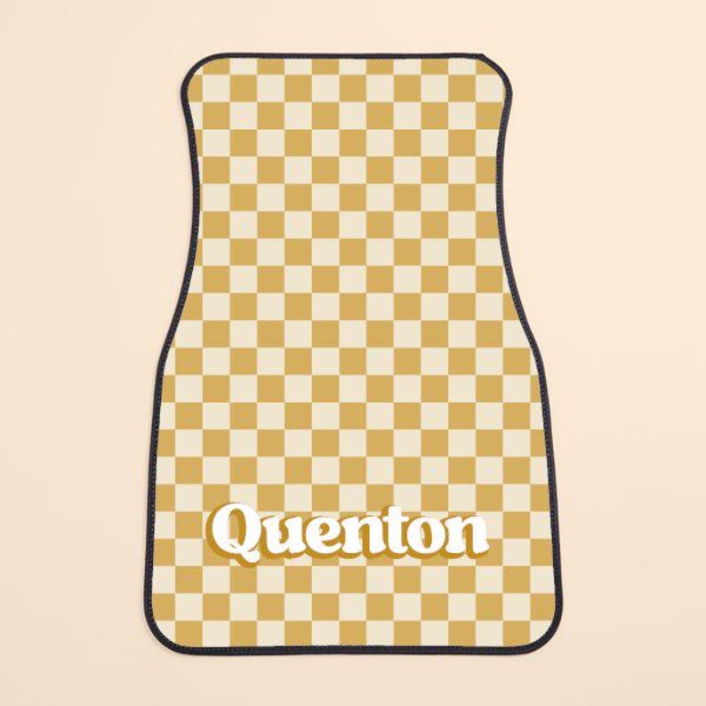 May include: A yellow and white checkered car floor mat with the name "Quenton" in a retro font.