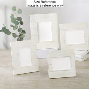 May include: Four white wooden picture frames of different sizes, arranged on a light wood surface. The frames have a rustic, weathered look and are ideal for displaying photos or artwork.