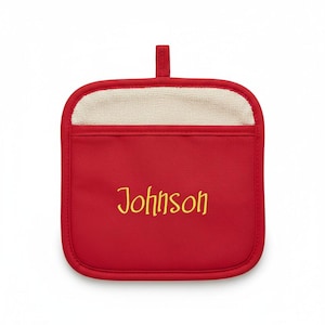 May include: A square red pot holder featuring a beige textured pocket at the top and a small fabric hanging loop. The word Johnson is embroidered in yellow script lettering across the center of the red fabric section of the pot holder.