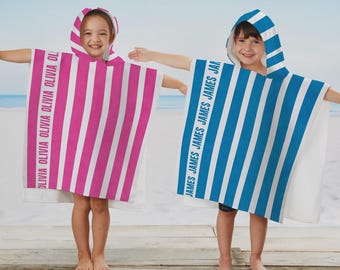 May include: Two hooded poncho towels with vertical stripes. One towel is pink and white with the name OLIVIA printed repeatedly in a vertical column. The other towel is blue and white with the name JAMES printed repeatedly in a vertical column.