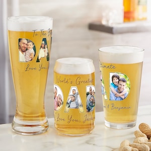 May include: Three glass beer mugs with personalized messages and photos. The mugs feature the word "DAD" with photos of fathers and children inside each letter. The mugs are filled with a light yellow liquid.