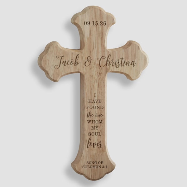 May include: A light brown wooden cross with decorative scalloped edges. The cross is engraved with the date 15.09.26, the names Jacob & Christina, and the text I HAVE FOUND the one WHOM MY SOUL loves, followed by SONG OF SOLOMON 3:4.