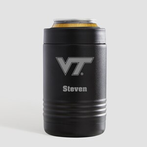 May include: A matte black cylindrical can cooler featuring the VT logo and the name Steven engraved in a light gray tone. The insulated beverage holder has a textured finish with horizontal ridges near the base and a metallic rim at the top.