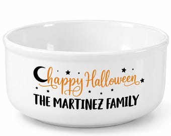 May include: A white ceramic bowl featuring a black crescent moon and small stars. The text "Happy Halloween" is printed in orange cursive script, followed by the text "THE MARTINEZ FAMILY" in bold black capital letters on the front surface.