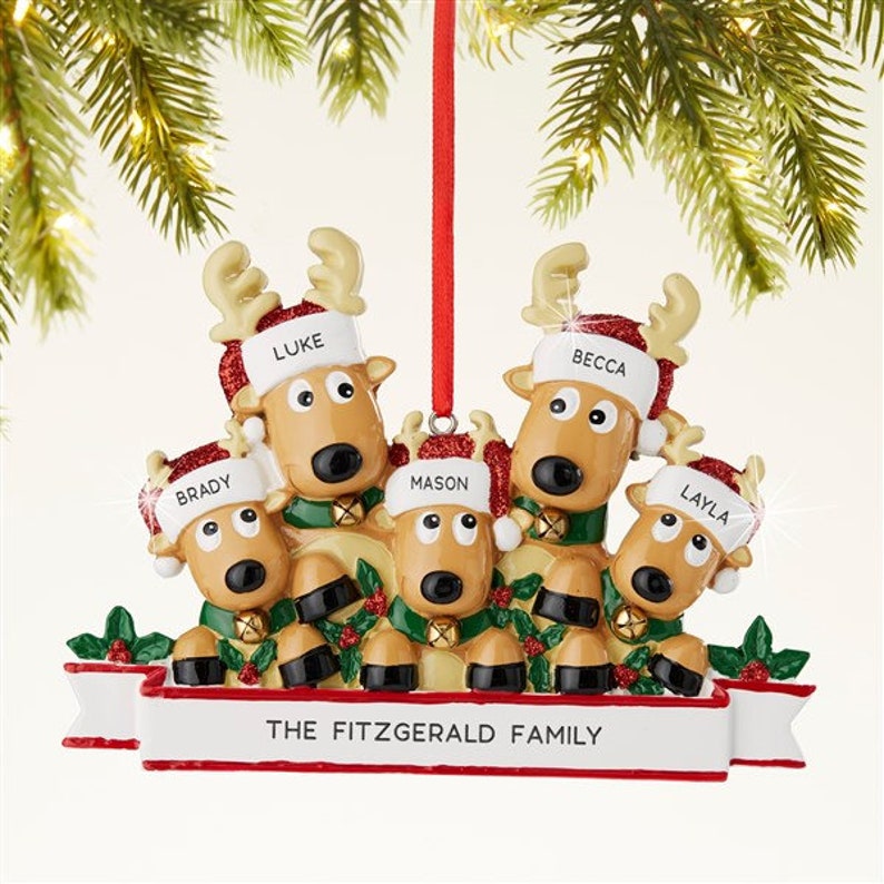 K&ouml;nnte beinhalten: Ein Weihnachtsschmuck mit einer Familie von f&uuml;nf Rentieren. Jedes Rentier tr&auml;gt einen Hut mit einem Namen: Luke, Becca, Brady, Mason und Layla. Auf dem Banner steht "THE FITZGERALD FAMILY". Die Rentiere tragen Weihnachtsm&uuml;tzen und gr&uuml;ne Schals.