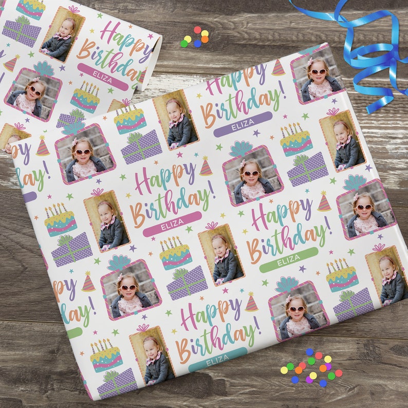 K&ouml;nnte beinhalten: Wei&szlig;es Geschenkpapier mit einem sich wiederholenden Muster aus bunten Geburtstagstorten, Geschenken, Partyh&uuml;ten und Sternen. Das Papier zeigt ein Foto eines jungen M&auml;dchens mit Sonnenbrille und dem Text "Happy Birthday!" mit dem Namen "Eliza", der sich wiederholt.