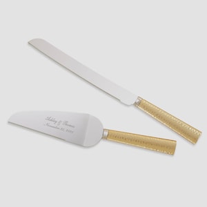 May include: A cake knife and server set with silver blades and gold hammered handles. The server is engraved with the names "Ashley & Thomas" and the date "November 26, 2026".