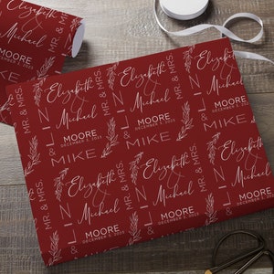 May include: Red wrapping paper with a white repeating pattern of the names Elizabeth and Michael, the date December 3, 2023, and the words "Mr. & Mrs."