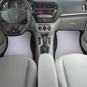 May include: A black steering wheel with a silver trim and a black dashboard with a silver trim. The car has a black center console with a silver gear shift knob and a black and silver radio.