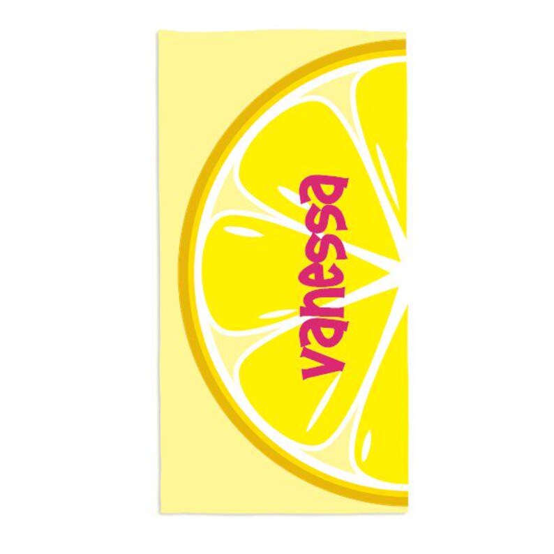 May include: A yellow beach towel with a large lemon slice graphic and the name "Vanessa" written in pink letters.