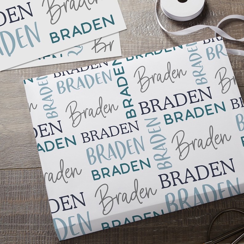 May include: White wrapping paper with a repeating pattern of the name "Braden" in various shades of blue and gray.