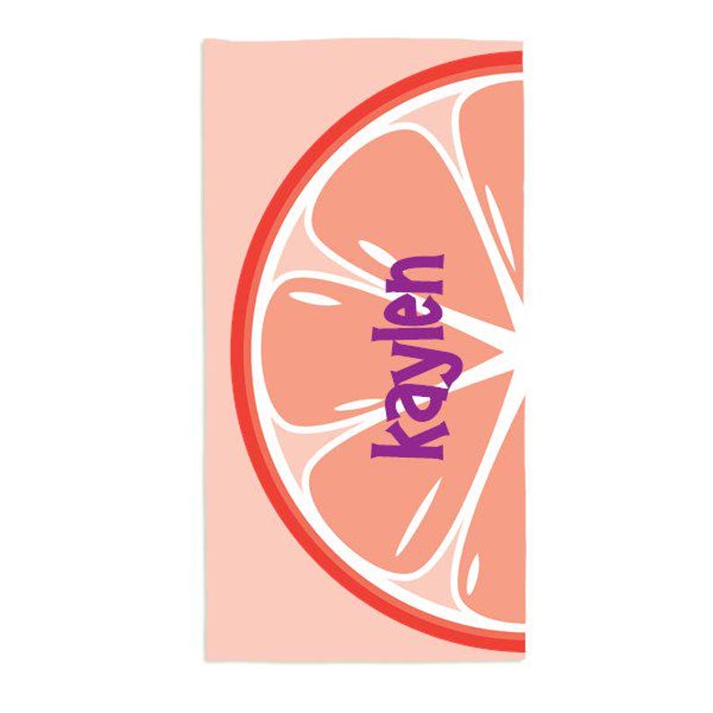 May include: Pink beach towel with a large pink grapefruit slice graphic. The grapefruit slice has a purple text overlay that says "Kaylen".