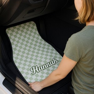 May include: A green and white checkered car floor mat with the name "Hannah" printed in a retro font.