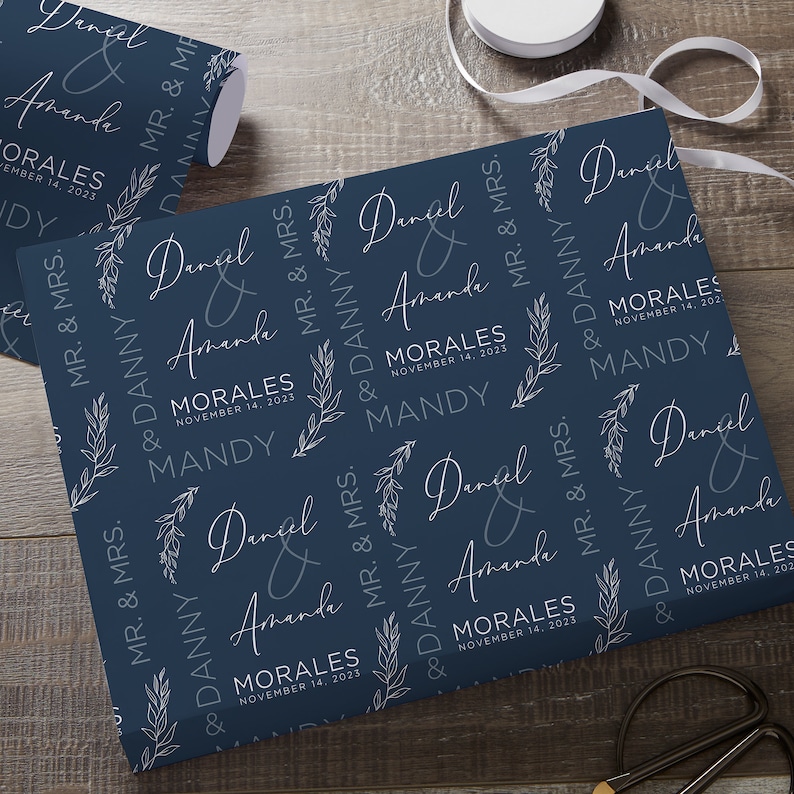 May include: Navy blue wrapping paper with a white floral design and the text "Daniel & Amanda Morales November 14, 2023 Mandy" repeated throughout.