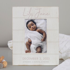 May include: White wooden picture frame with a photo of a baby girl. The frame has the name "Lily Jane" written in pink script and the date "December 3, 2023" with the baby's birth weight and length.