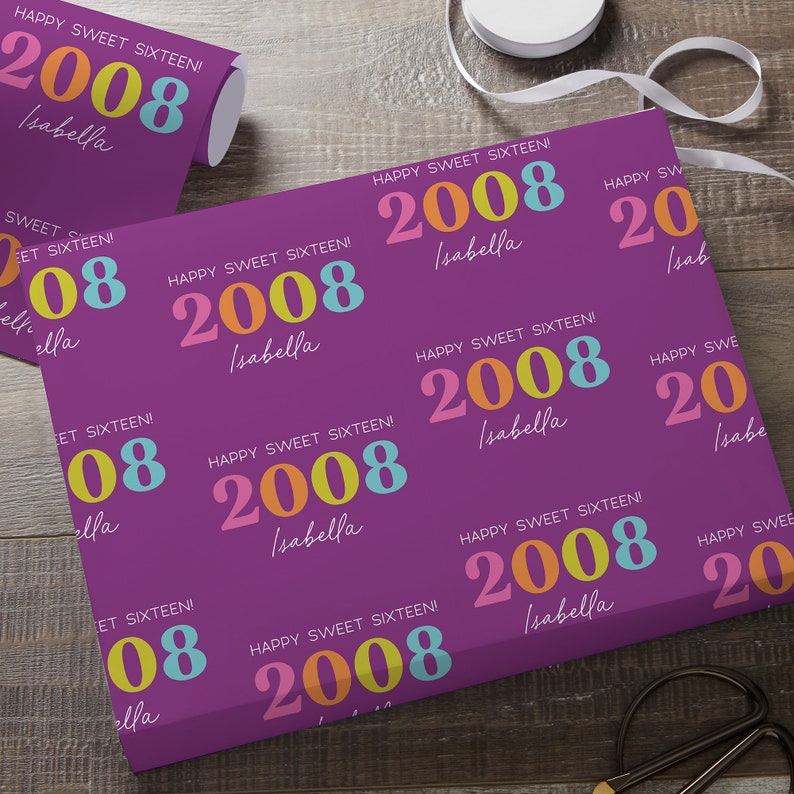 May include: Purple wrapping paper with a repeating pattern of the text "HAPPY SWEET SIXTEEN!" and the year "2008" in colorful text. The name "Isabella" is also printed on the paper.