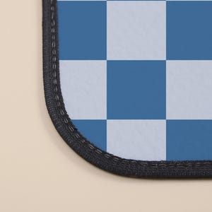 May include: A blue and white checkered mouse pad with a black stitched edge.