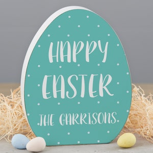 May include: A teal blue wooden egg-shaped sign with white polka dots and the text "Happy Easter" and "The Garrisons".
