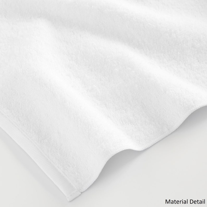 May include: Close-up of a white, soft, and fluffy towel. The towel is made of a plush material and has a smooth texture.