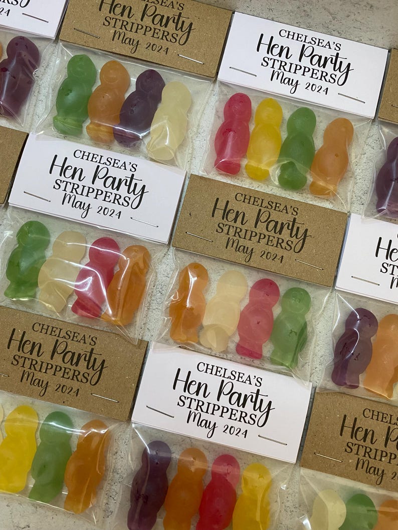 May include: A set of small, clear plastic bags filled with colorful jelly candies. Each bag has a white label with the text "Chelsea's Hen Party Strippers May 2024".