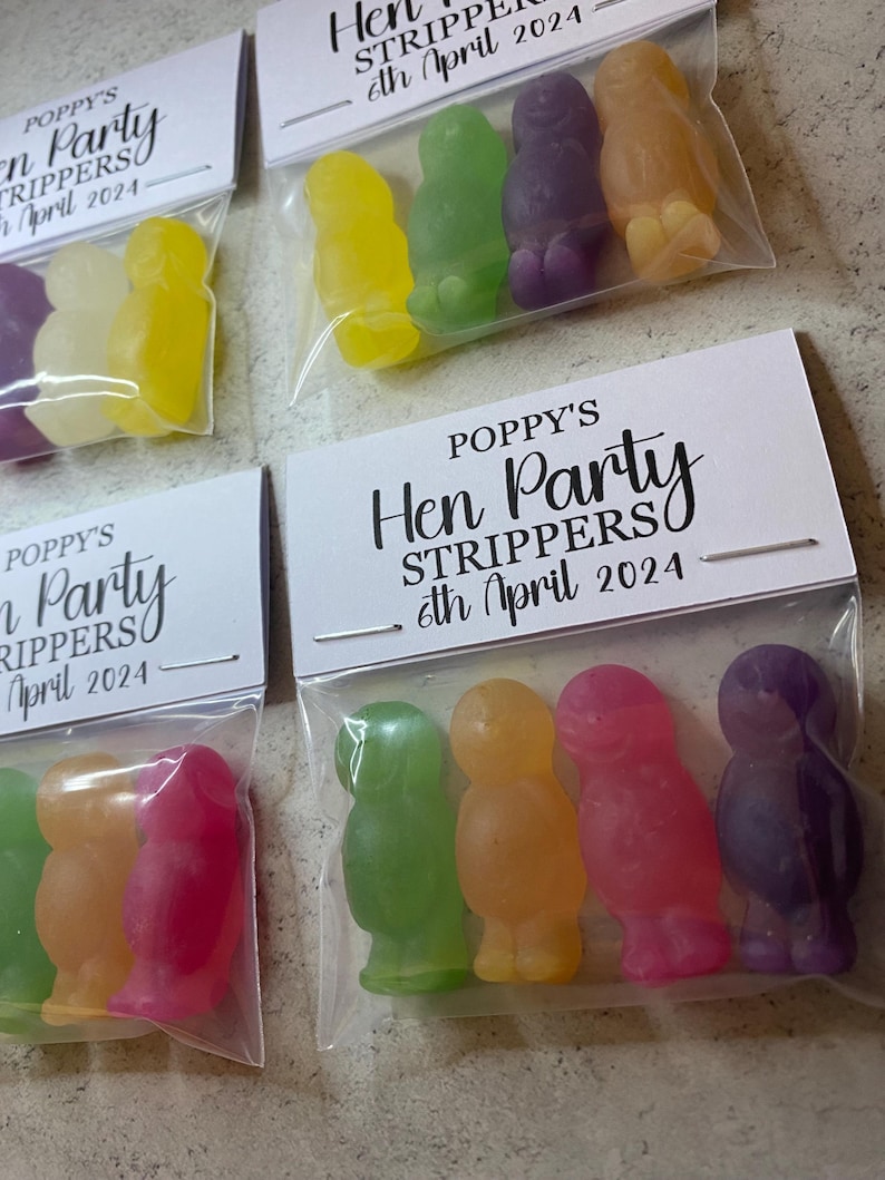 May include: Four small bags with clear cellophane fronts and white card backs. Each bag contains four gummy candies shaped like people. The cards have the text "Poppy's Hen Party Strippers 6th April 2024".