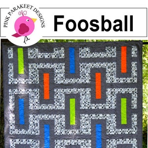 Könnte beinhalten: Ein Quiltmuster namens "Foosball" mit grauem Hintergrund und einem Zickzackmuster. Der Quilt ist aus Stoffstreifen in Blau, Grün und Orange gefertigt. Der Text "Quick Strip Piecing!" befindet sich in einem weißen Kreis in der unteren rechten Ecke des Quilts.