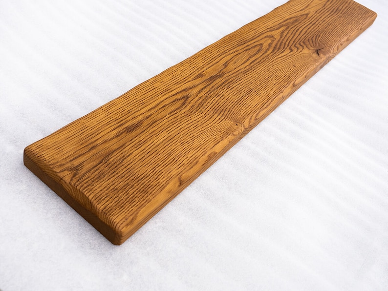 May include: A long, rectangular piece of wood with a natural, brown finish. The wood has a grain pattern and is smooth to the touch.