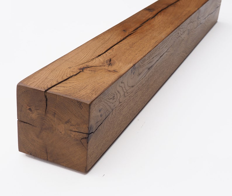 May include: A large, rustic, brown wooden beam with a natural finish. The beam has a large crack running down the center. The beam is made of reclaimed wood and has a unique character.