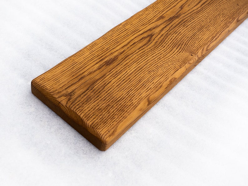May include: A long, rectangular piece of wood with a natural, brown finish. The wood has a grain pattern and is smooth to the touch.