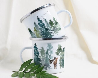 May include: Two white enamel mugs with a forest scene and a deer. The top mug has a watercolor design of a forest with green and blue trees. The bottom mug has a similar design with a brown deer standing in the forest.