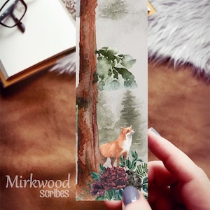 May include: A watercolor bookmark featuring a fox standing in a forest with a tree trunk and green foliage. The fox is orange and white with a bushy tail. The background is a soft gray with hints of green and brown. The bookmark has the text "Mirkwood Scribes" at the bottom.