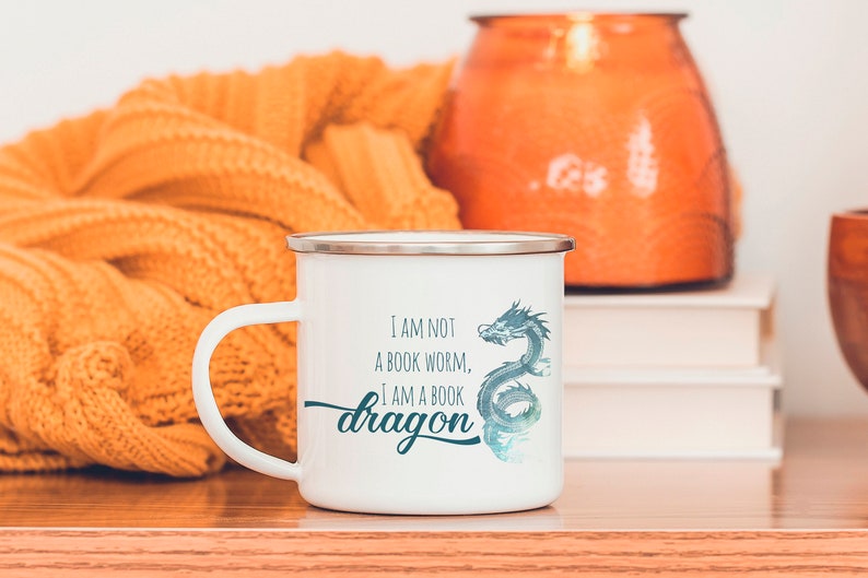 May include: White enamel mug with a blue dragon design and the text "I am not a book worm, I am a book dragon".
