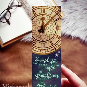 May include: A blue bookmark with a gold clock face and stars. The text on the bookmark reads "Second star to the right and straight on 'til morning".