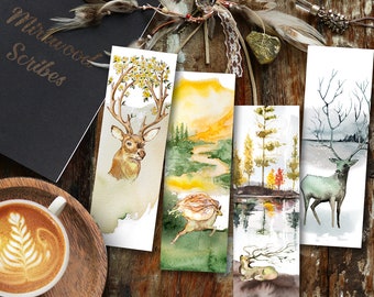 May include: Set of four watercolor bookmarks featuring deer, a forest scene, a lake, and a winter scene. The bookmarks are all rectangular and have a white background.