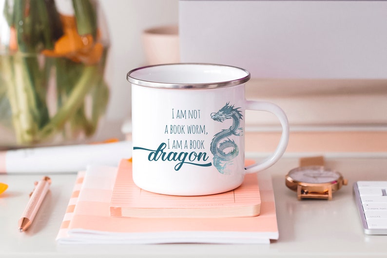 May include: White enamel mug with a blue watercolor dragon design and the text "I am not a book worm, I am a book dragon".