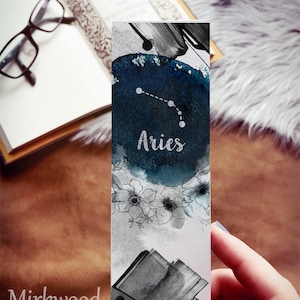 May include: A rectangular bookmark featuring an Aries constellation design. The bookmark has a dark blue watercolor background with the Aries symbol and the word "Aries" in white. The bottom of the bookmark has a floral design and the text "Mirkwood scribes".