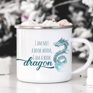 May include: White enamel mug with a blue and green dragon design and the text "I am not a book worm, I am a book dragon".
