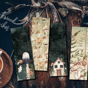 Puede incluir: Cuatro marcapáginas ilustrados con diseños de bosque y setas. Un marcapáginas presenta una seta con un caracol, otro una casita y un tercero un patrón repetido de criaturas del bosque. El texto "Mirkwood Scribes" es visible.
