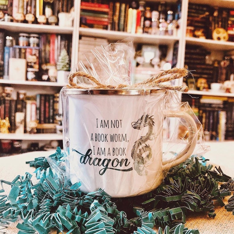 May include: White enamel mug with a green dragon design and the text "I am not a book worm, I am a book dragon".