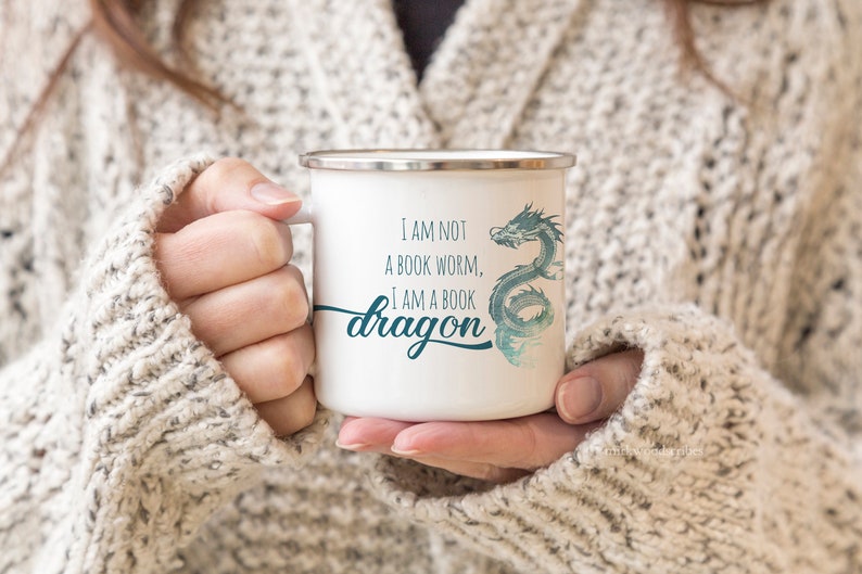 May include: White enamel mug with a blue and green dragon design and the text "I am not a book worm, I am a book dragon".