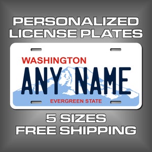 May include: A blue and white personalized license plate with the text "WASHINGTON" and "EVERGREEN STATE" in red. The plate also features a mountain range graphic and the text "ANY NAME" in black.