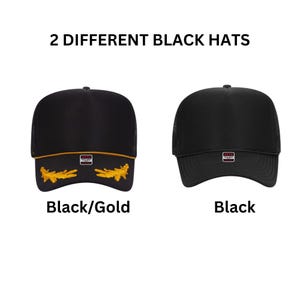 May include: Two black trucker hats with mesh backs. The left hat features gold embroidery on the brim and a gold cord across the base of the crown. The right hat is solid black. Both hats have a small rectangular Otto brand label on the front.