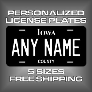 May include: Black and white personalized license plate with the text "IOWA" and "ANY NAME" and "COUNTY".  The plate is available in 5 sizes and includes free shipping.