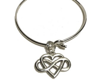 May include: A silver bangle bracelet with a silver infinity heart charm. The bracelet is adjustable and has a simple design.
