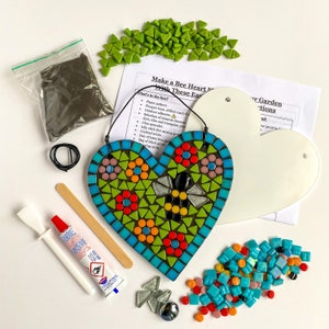 May include: A bee heart mosaic craft kit with all the materials needed to create a colorful mosaic heart with a bee design. The kit includes a pre-cut heart-shaped base, a bag of colorful mosaic tiles, grout, a spreader, and instructions.